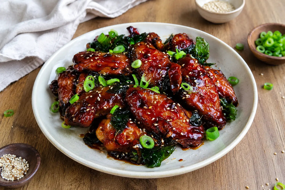 Caramelized peanut butter chicken wings with sesame seeds and green onions